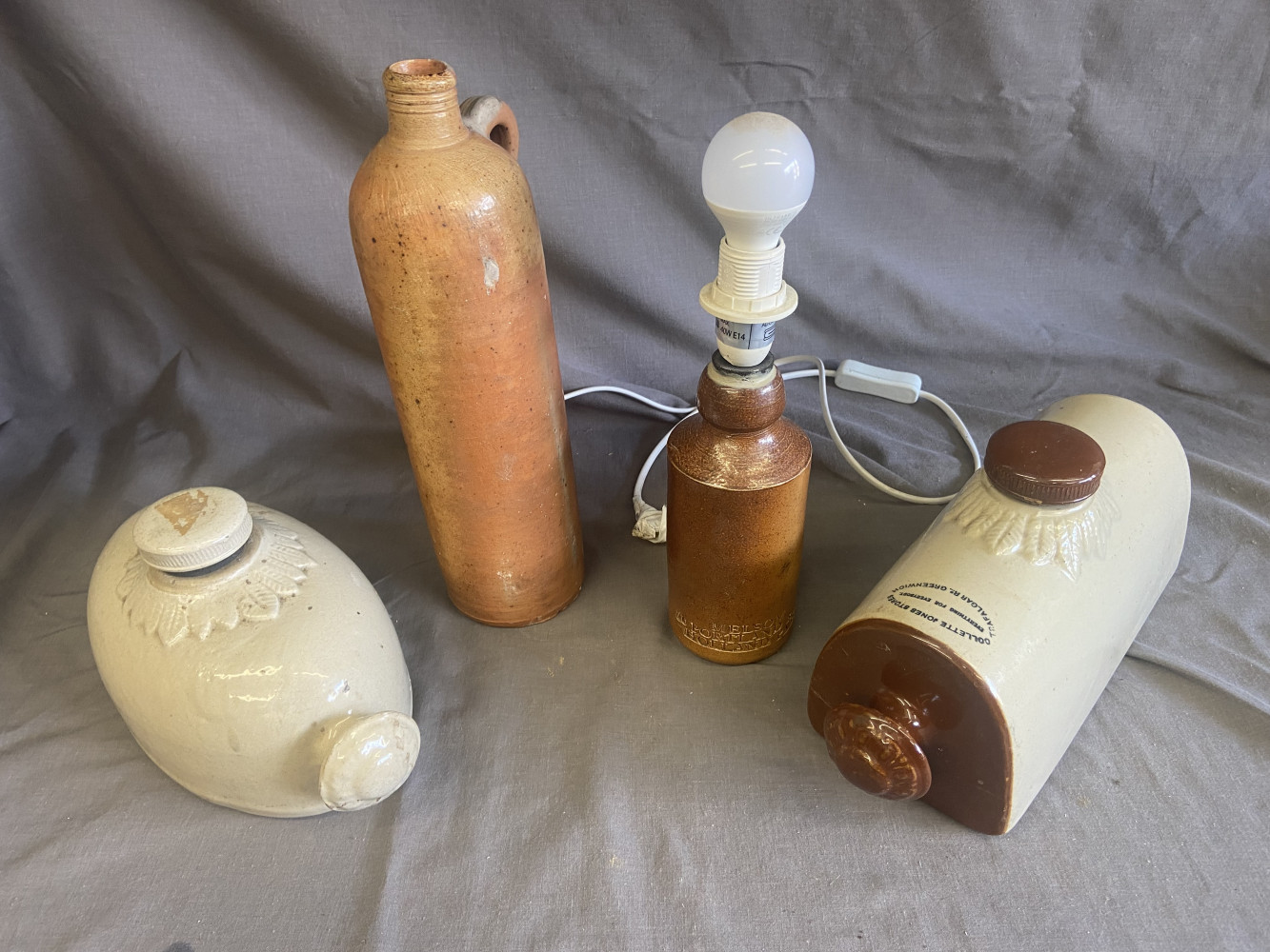 Antique bed warmers and stoneware bottle and lamp