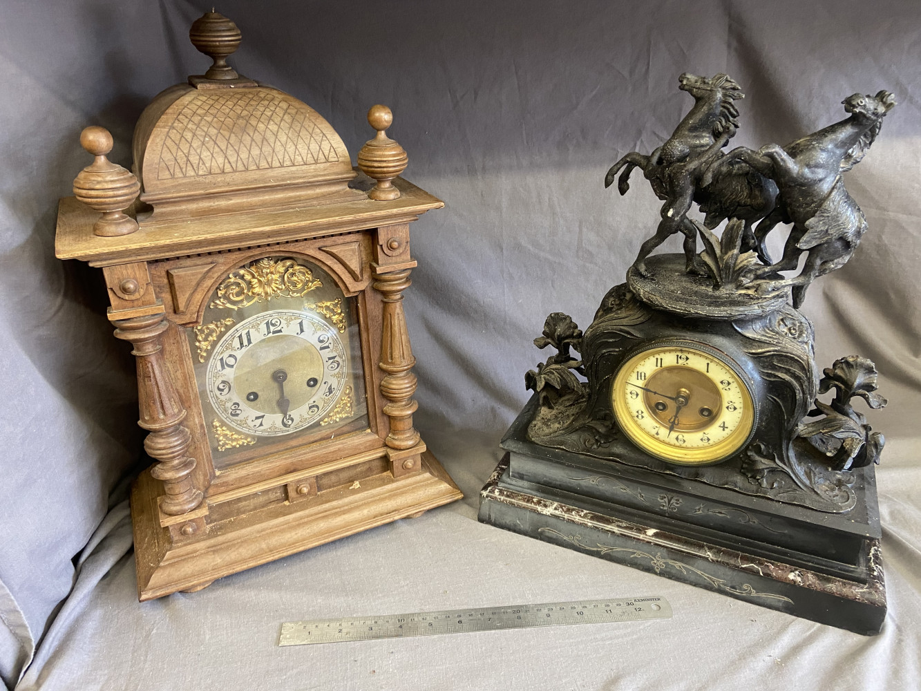 Two large mantel clocks wooden one need restoration and has a spare movement and the other one is A/F to the figures on the top