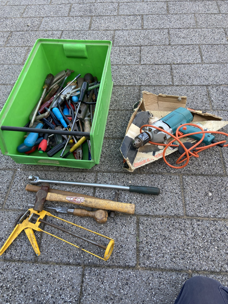 Box full of tools and electric drill with chuck key