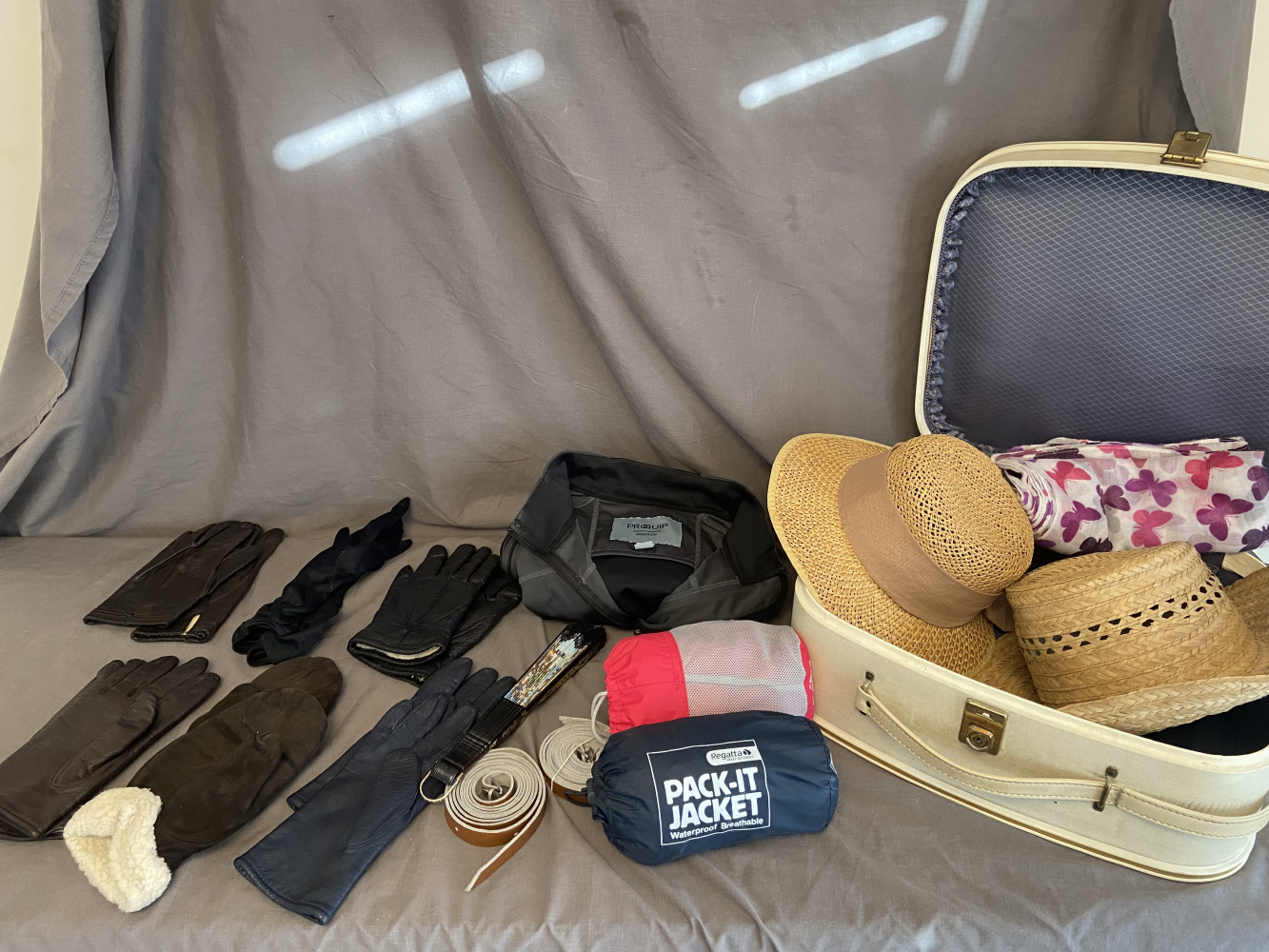 Vintage suitcase with hats, and other mixed clothing items
