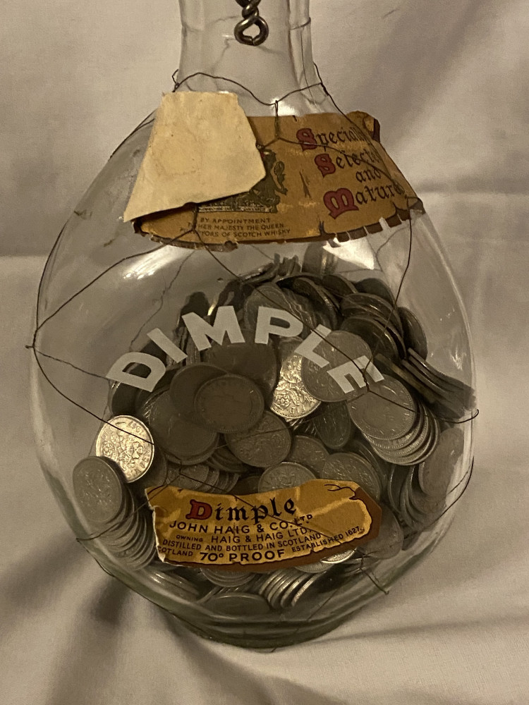 Vintage Dimple whiskey bottle full of old 6 pence pieces