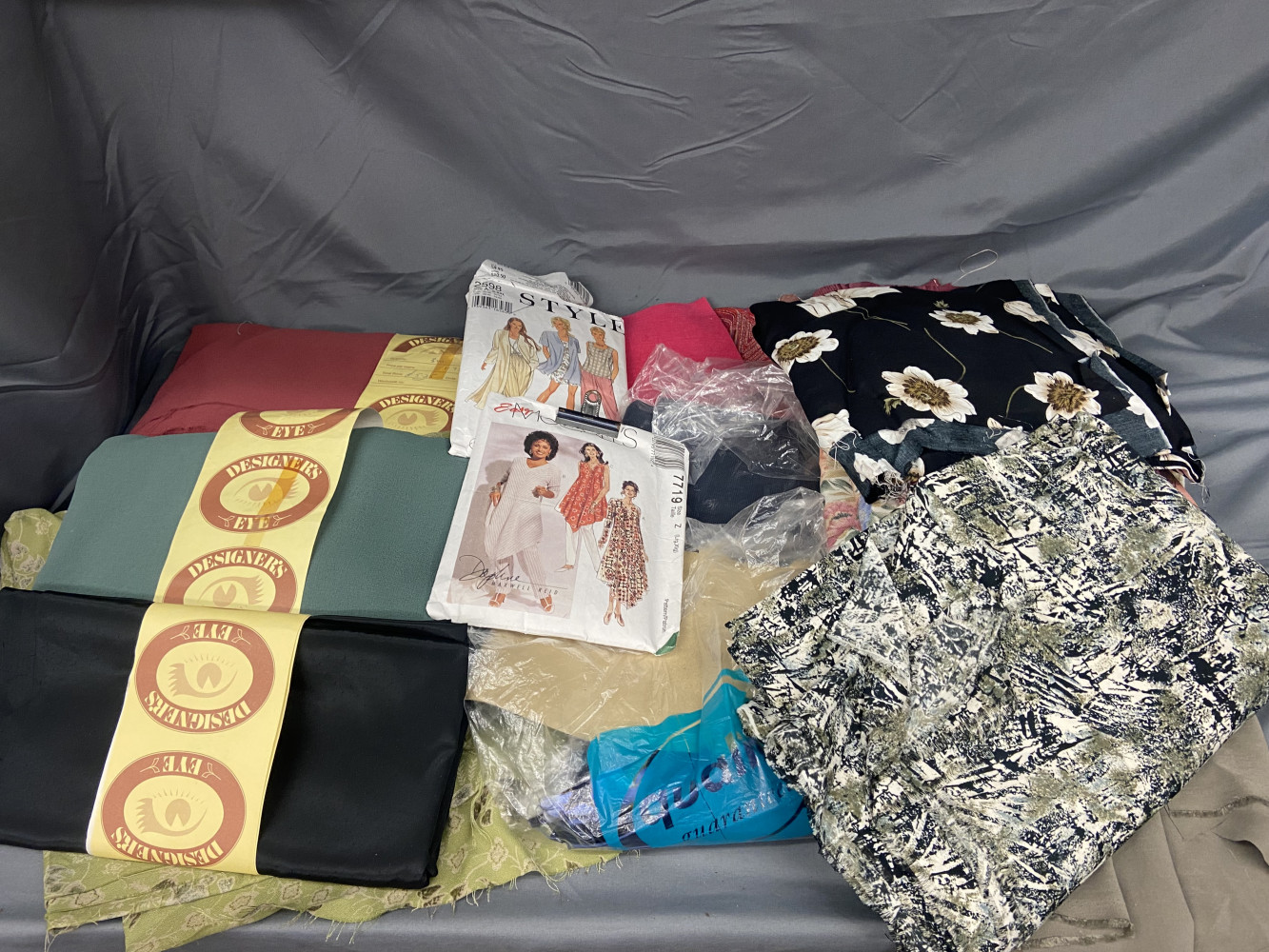 Large box of new material and some dress making patterns