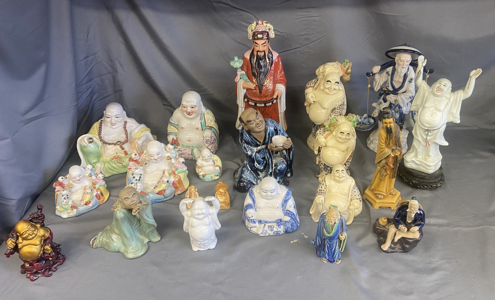 collection of Chinese and Japanese porcelain figurines depicting the Laughing Buddha (Budai or Hotei) and other figures