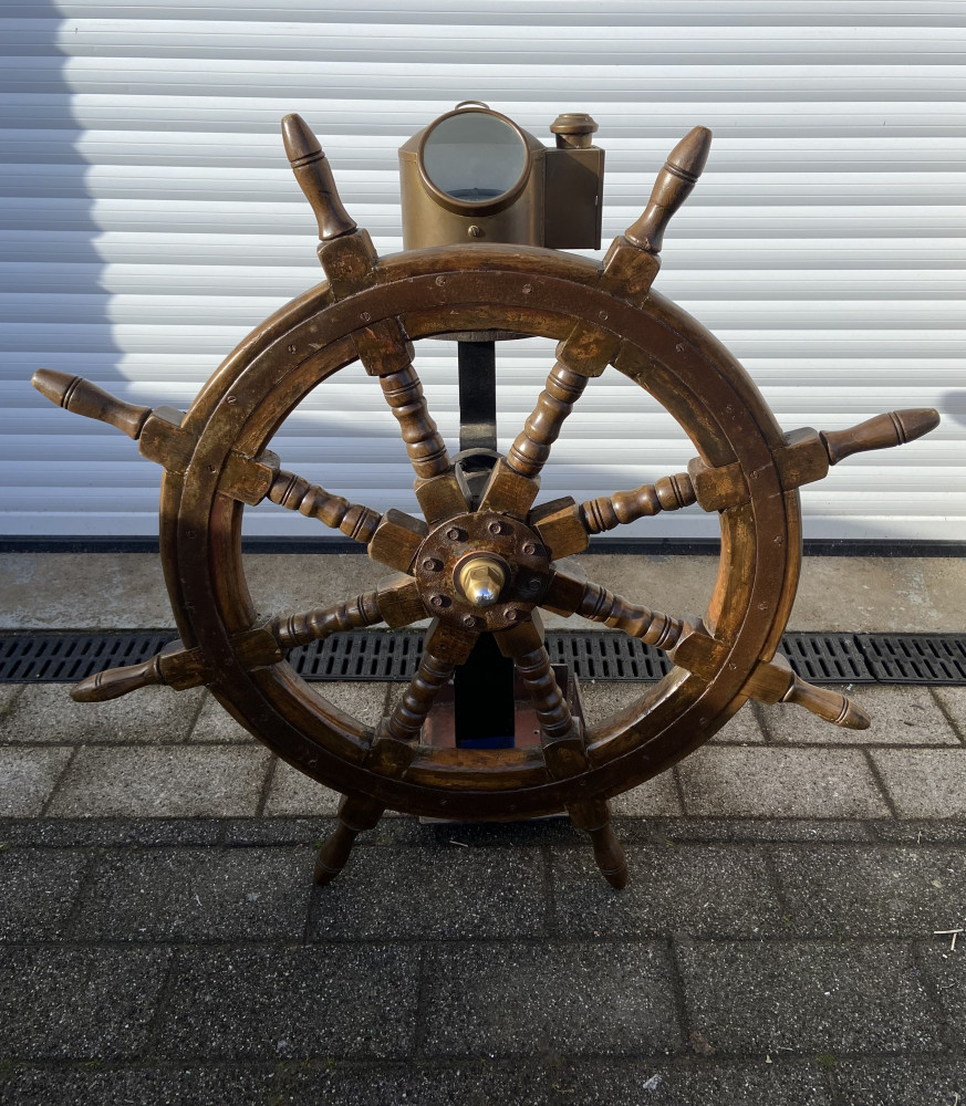 Large ships wheel on stand with compass
