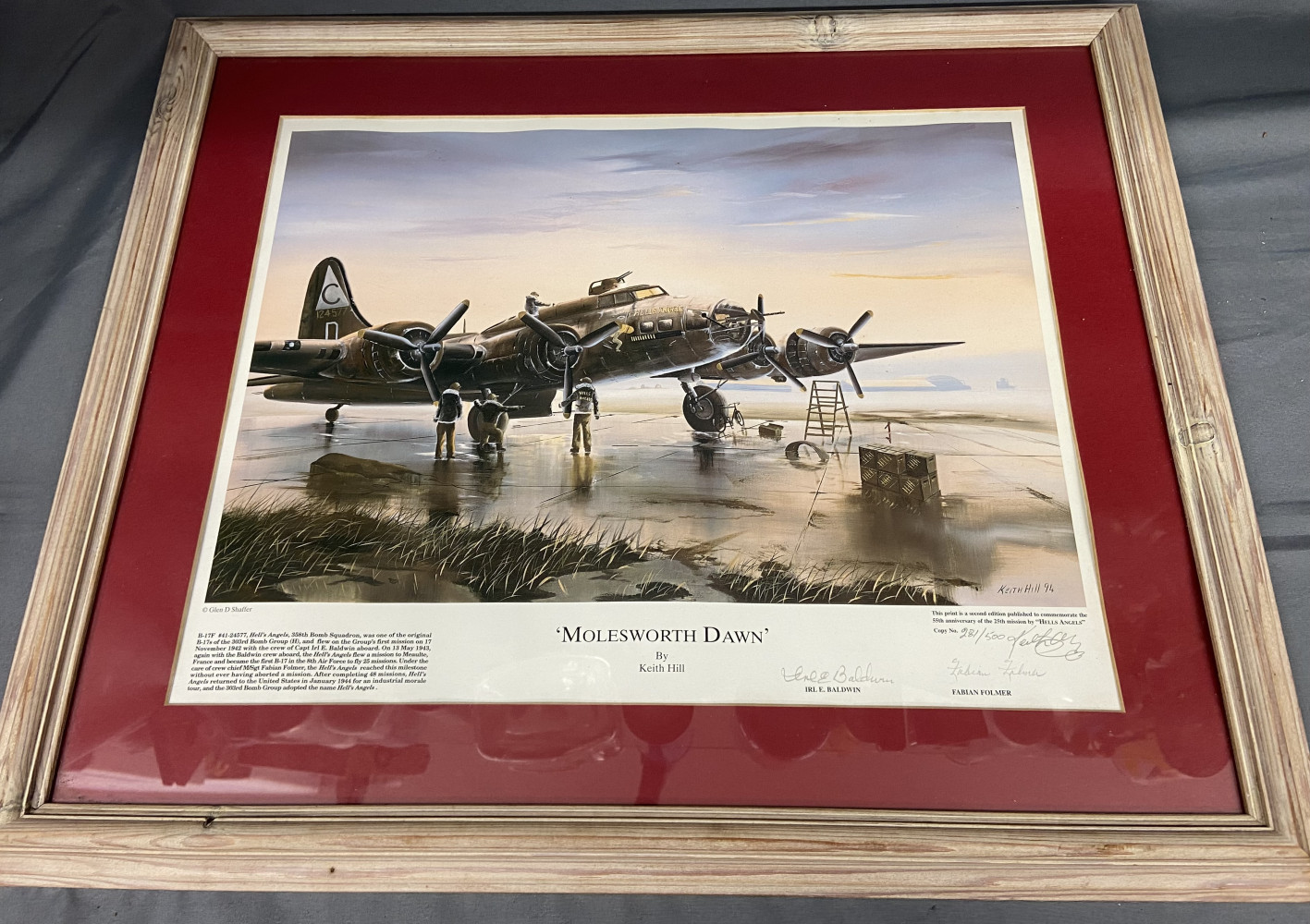 Framed limited edition print titled 'Molesworth Dawn' by the British artist Keith Hill. The print depicts a B-17 Flying Fortress bomber, specifically the 'Hells Angels' of the 303rd Bomb Group, at dawn at RAF Molesworth. Signed by artist and pilotes