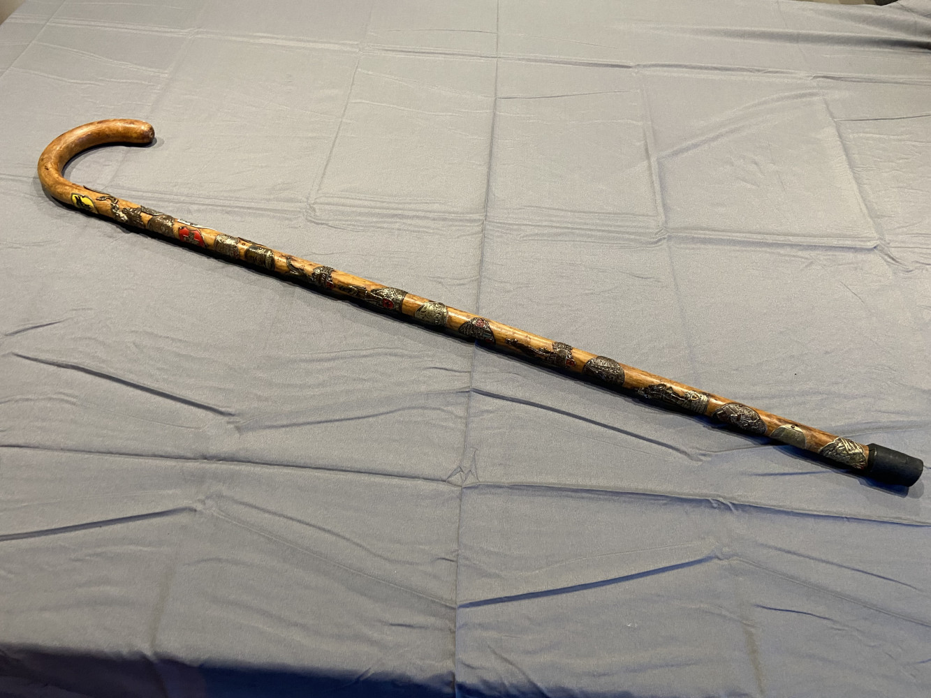 Walking stick covered in collectable Swiss tourist badges