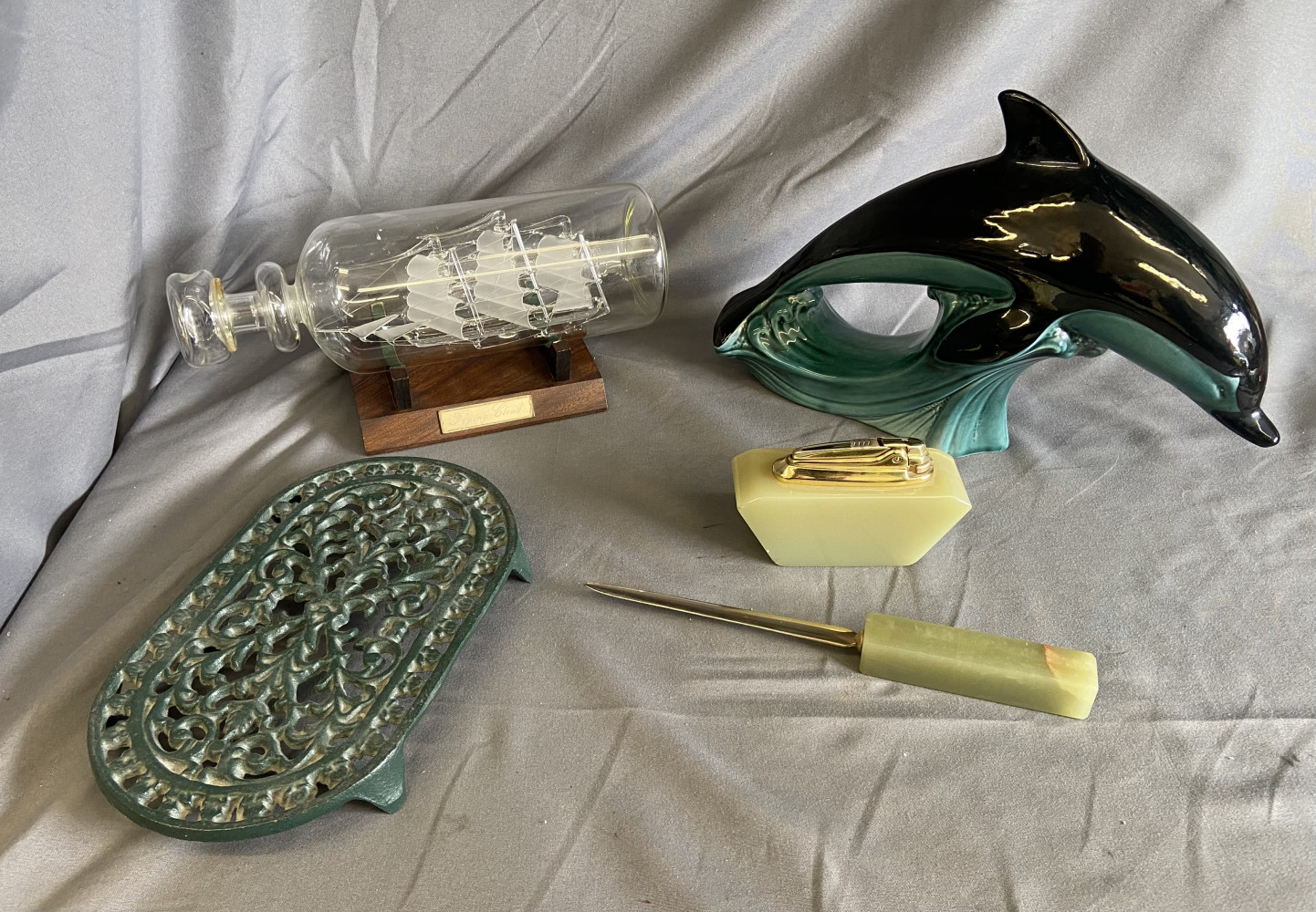 Onyx table lighter and letter opener, Poole pottery Dolphin, metal stand and glass shop in a bottle