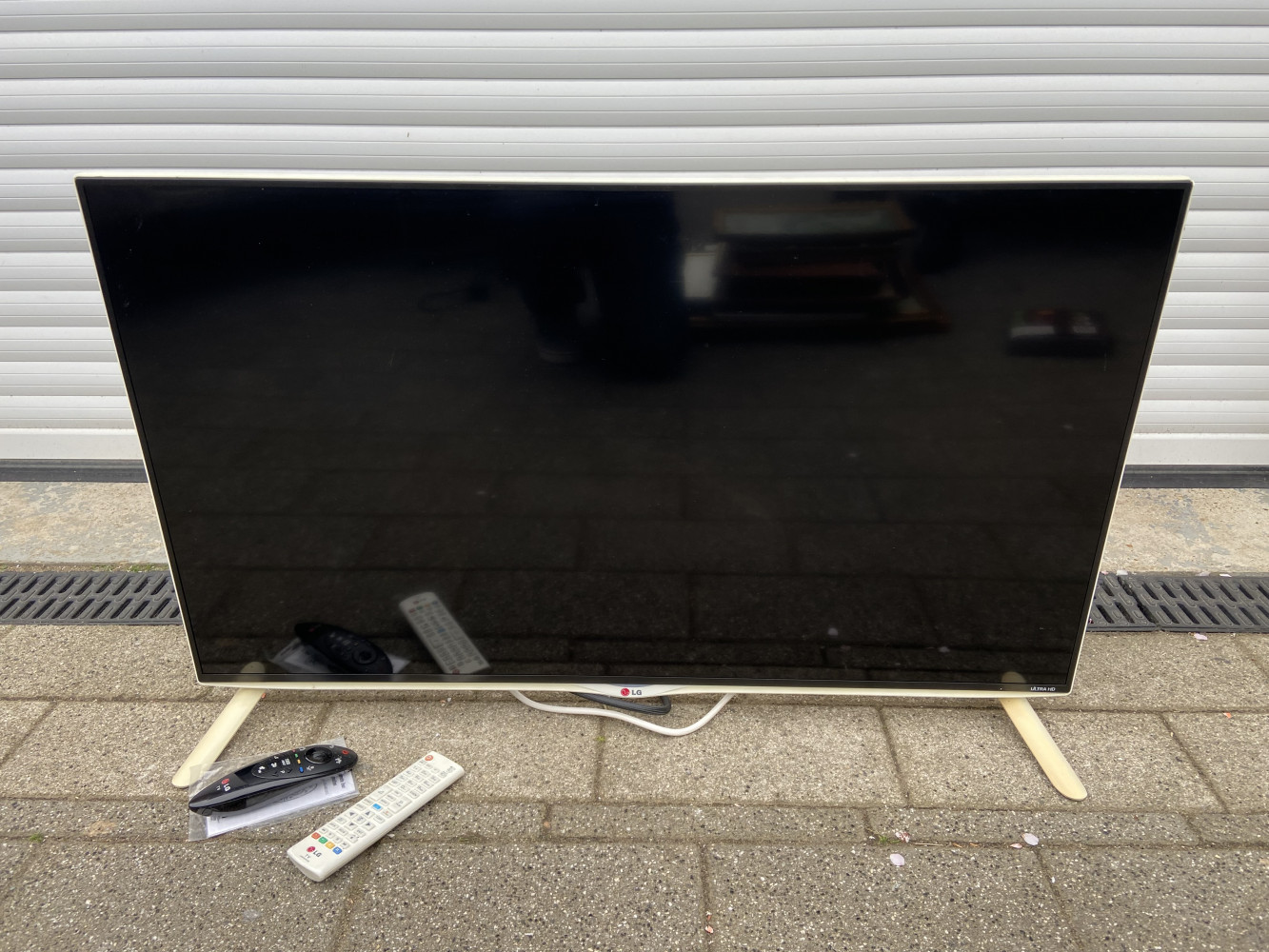 White cased LG TV with remotes