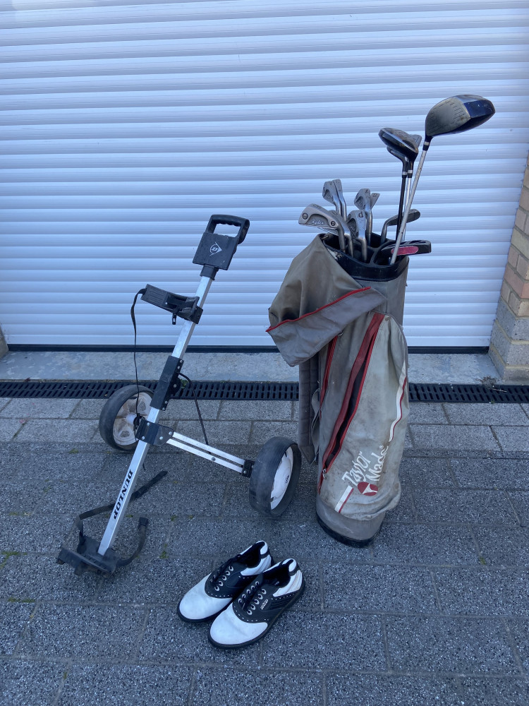 Golf trolley, golf shoes and bag full of clubs