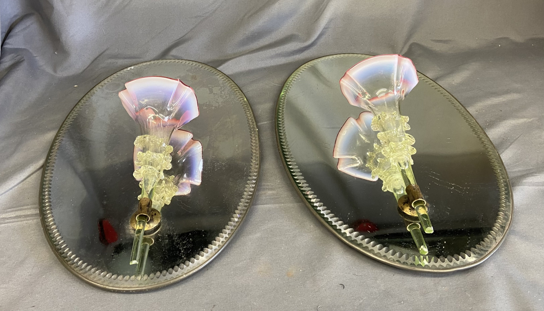 Two antique Victorian-era wall sconces featuring green glass trumpet vases with opalescent glass