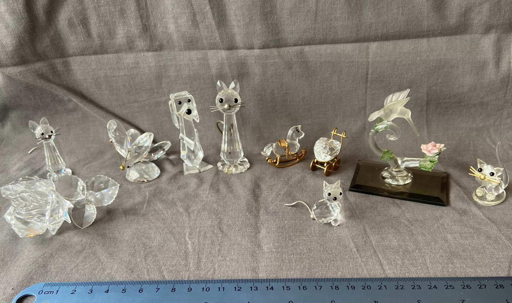 Mixed glass and Swarovski crystal animal figurines, including cats, a dog, a rocking horse, and a butterfly