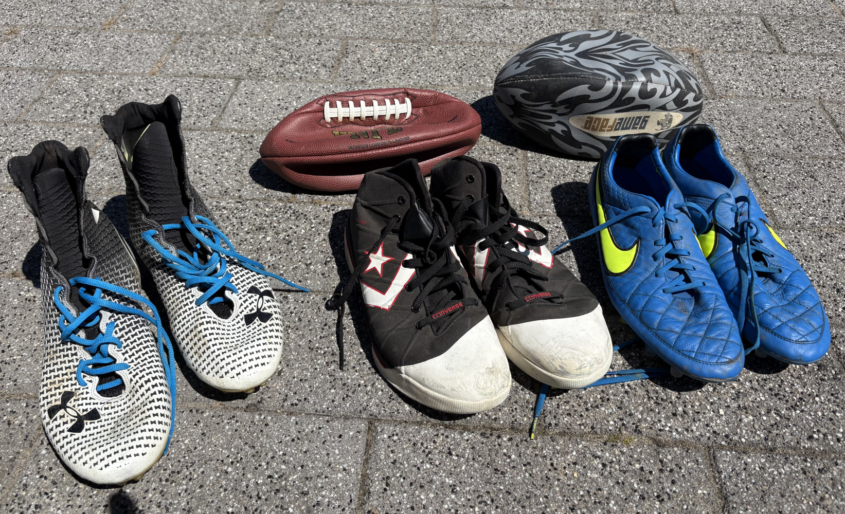 Converse boots and football boots and two rugby balls