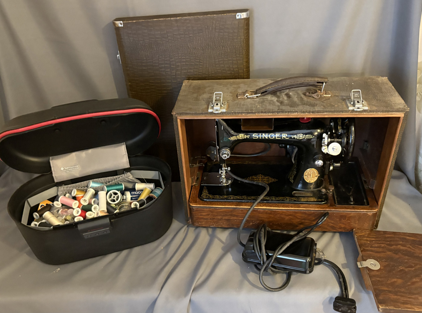 Vintage Singer sewing machine and tub full of cottons and other sewing items