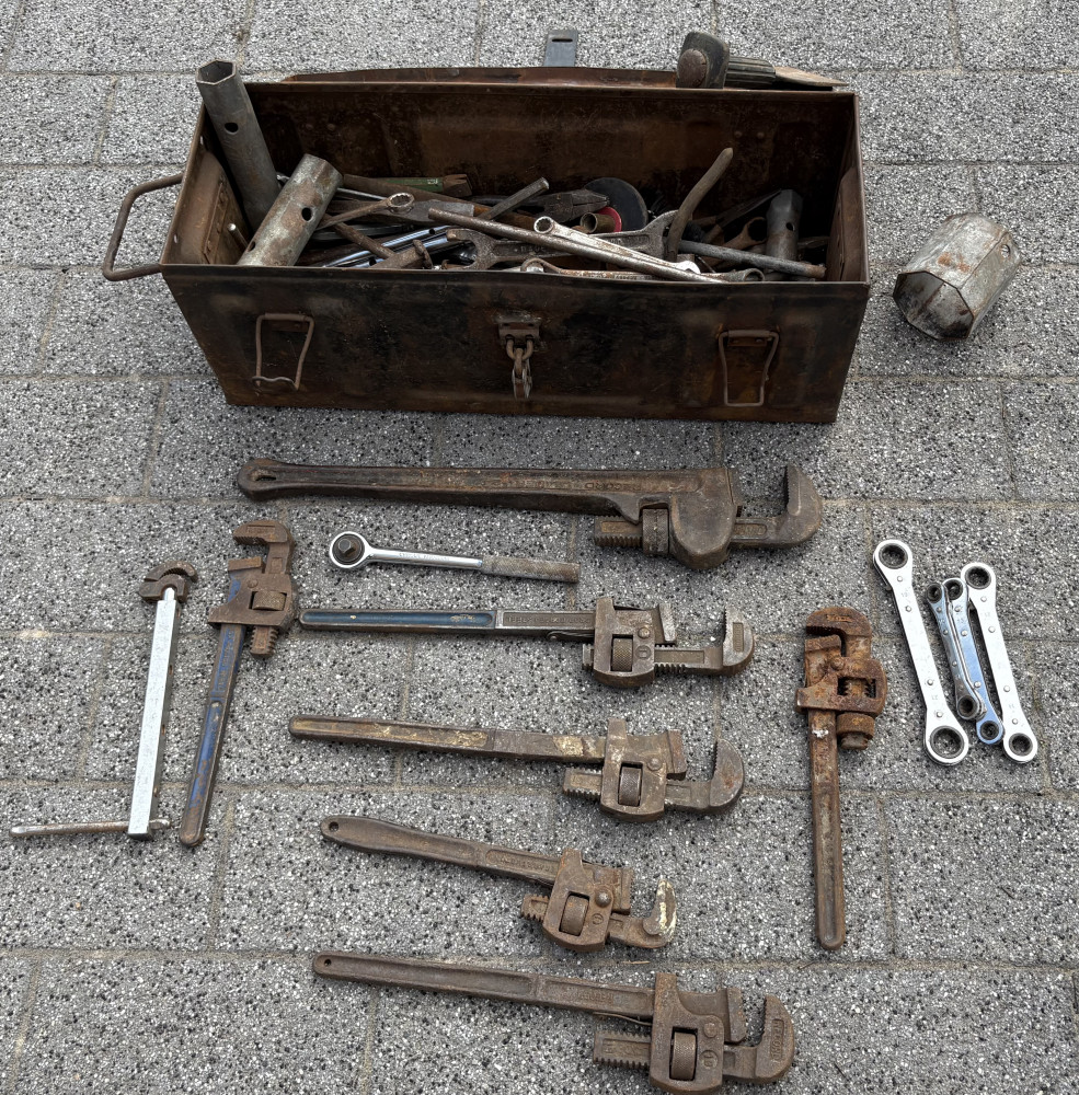 Metal tool box loaded with industrial tools including set of wrenches