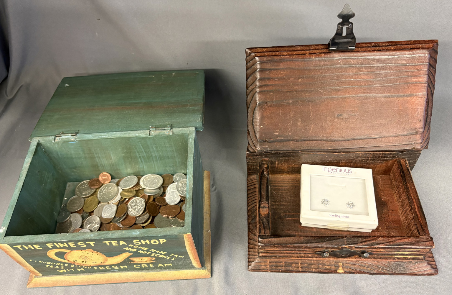 Two small wooden boxes one filled with various coins and the other a pair of silver earrings