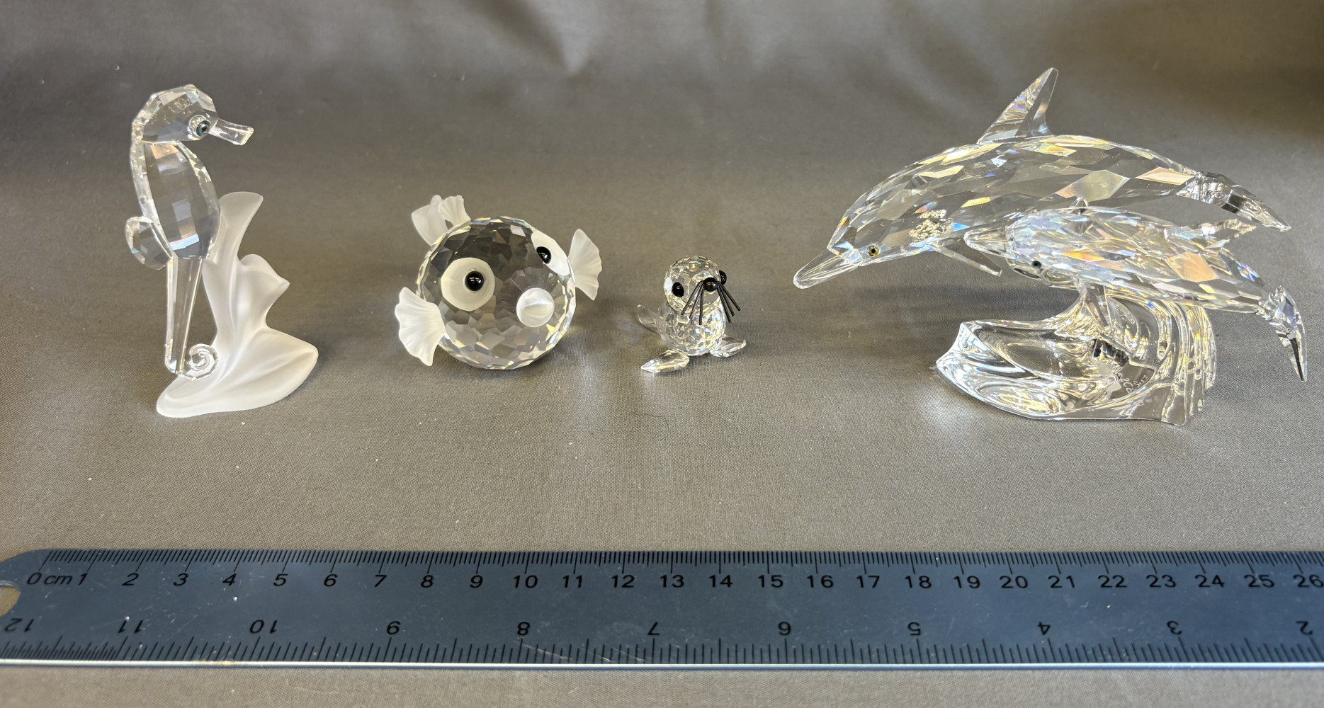 Swarovski 1990 Annual Edition "Lead Me" Dolphins no 153850, Swarovski blowfish 010013, Swarovski Crystal Seahorse figurine 168683 and a Swarovski Crystal Mini Baby Seal Figurine no 012530.