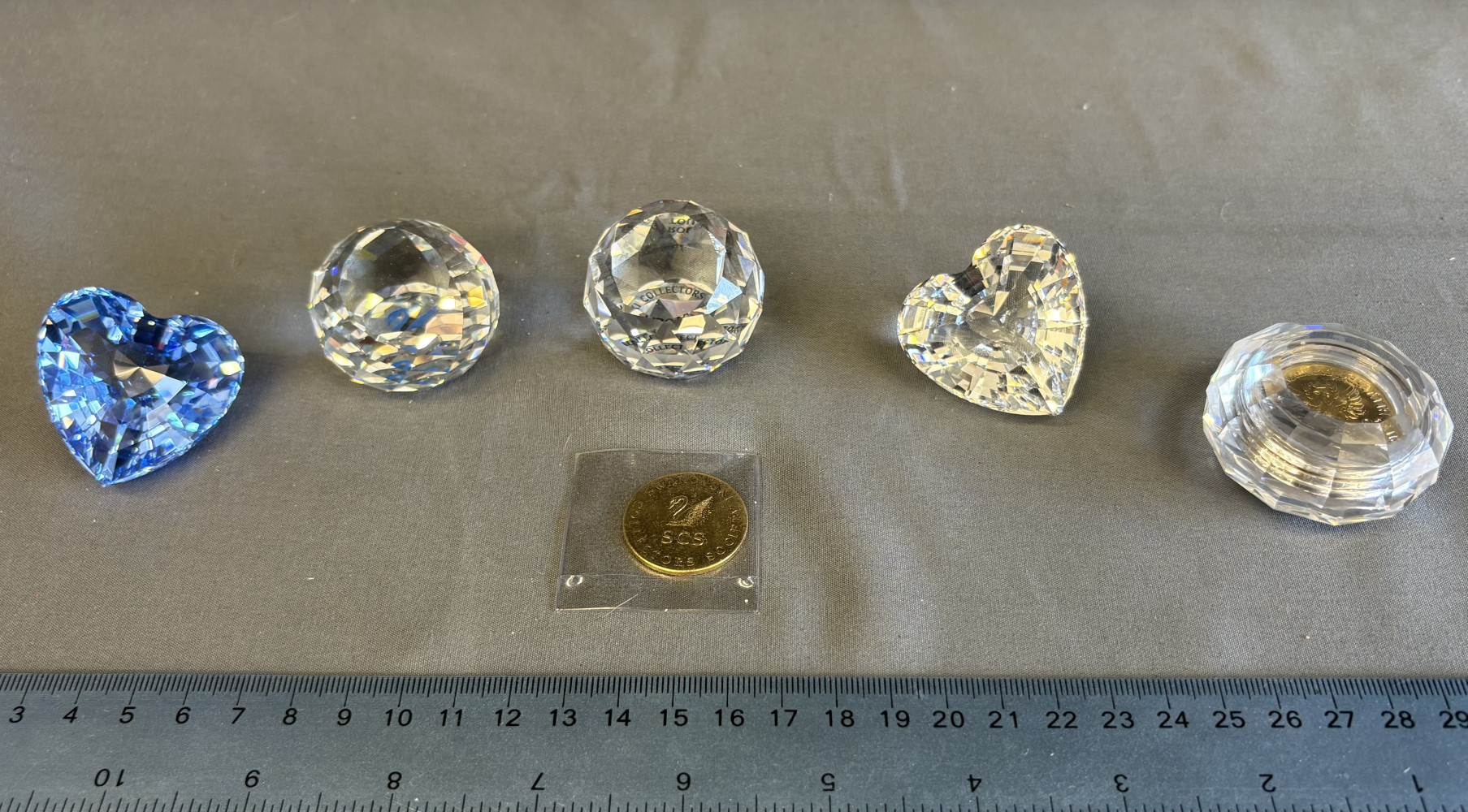 Swarovski 1996 SCS Renewal Gift no 199130, Swarovski SCS 1997 Renewal Gift Blue Heart no 210899, two commerative paper weights one containing a coin and a Swarovski Crystal Society (SCS) gold-tone token or commemorative collector's coin