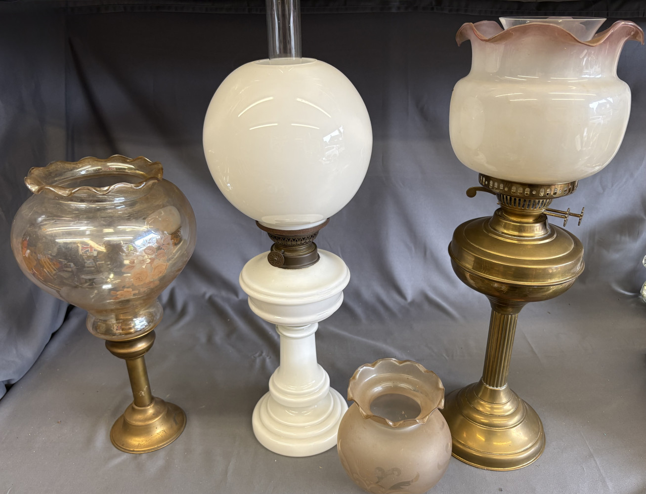 3 oil lamps and spare shade, white one approx 57 cms tall