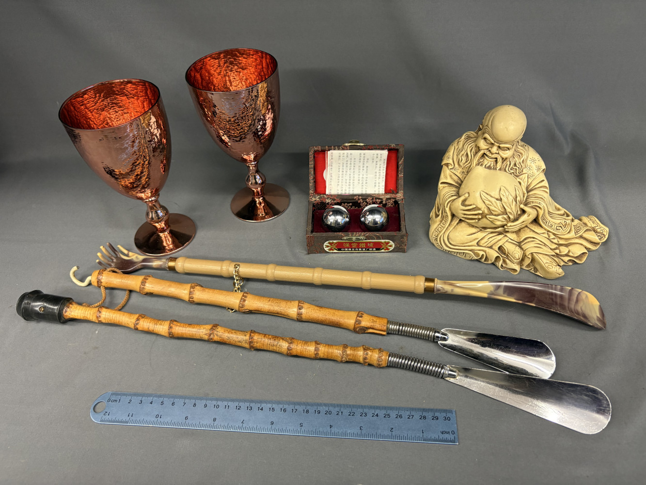 Back scratcher, shoe horns, resin buddha, chime balls and copper effect glasses