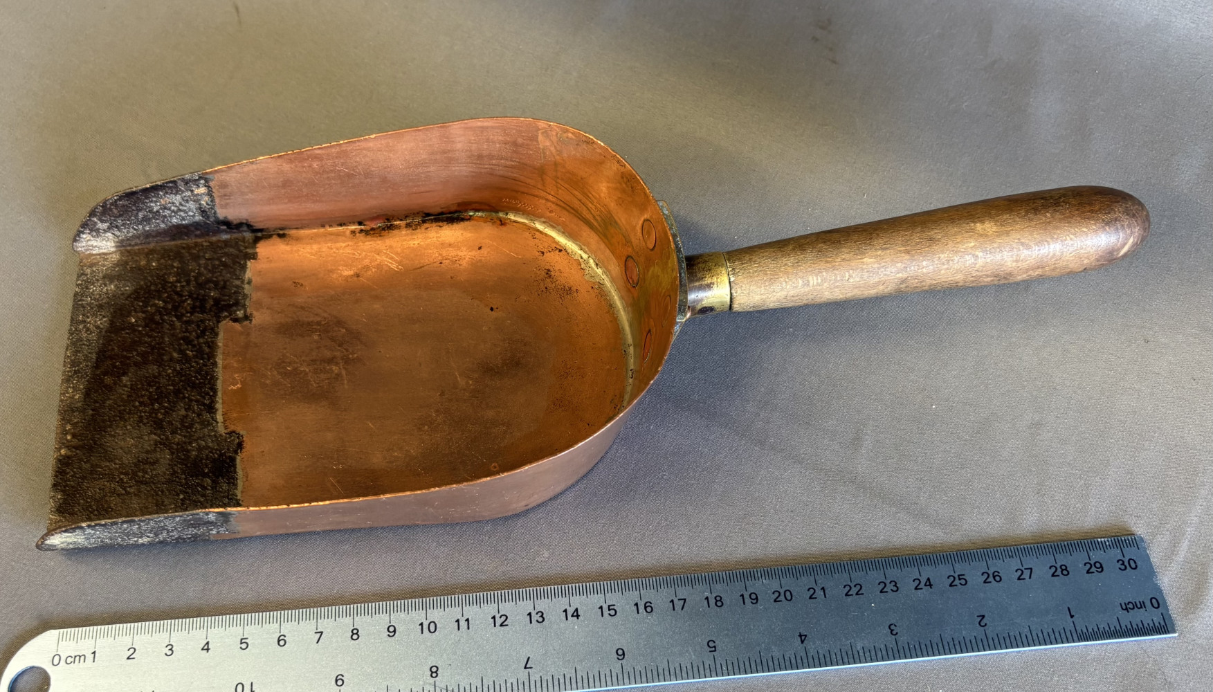vintage 19th-century bank clerk's coin or cash money shovel, featuring a hand-formed copper body with a dovetailed or riveted steelware plate at the tip and a turned wooden handle