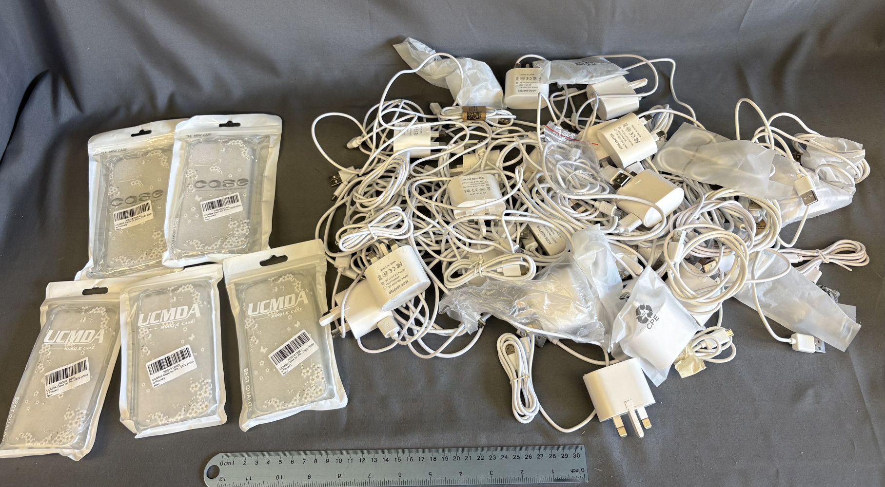 Box of chargers, USB charging cables and some phone cases