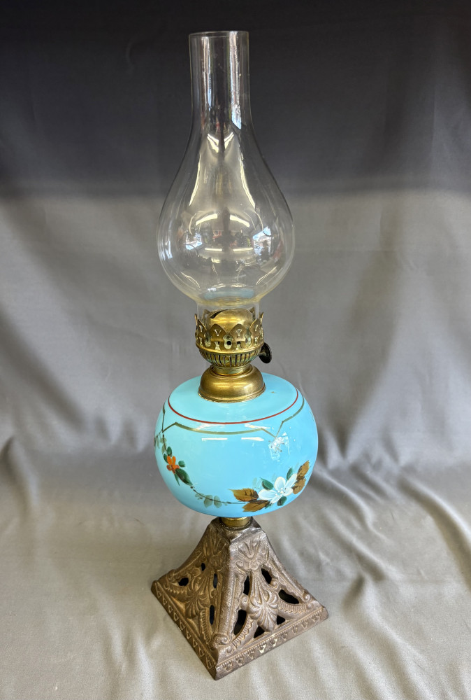 antique Victorian-era oil or kerosene lamp featuring a bright turquoise-blue hand-painted glass font and a decorative cast-metal base 42cms tall