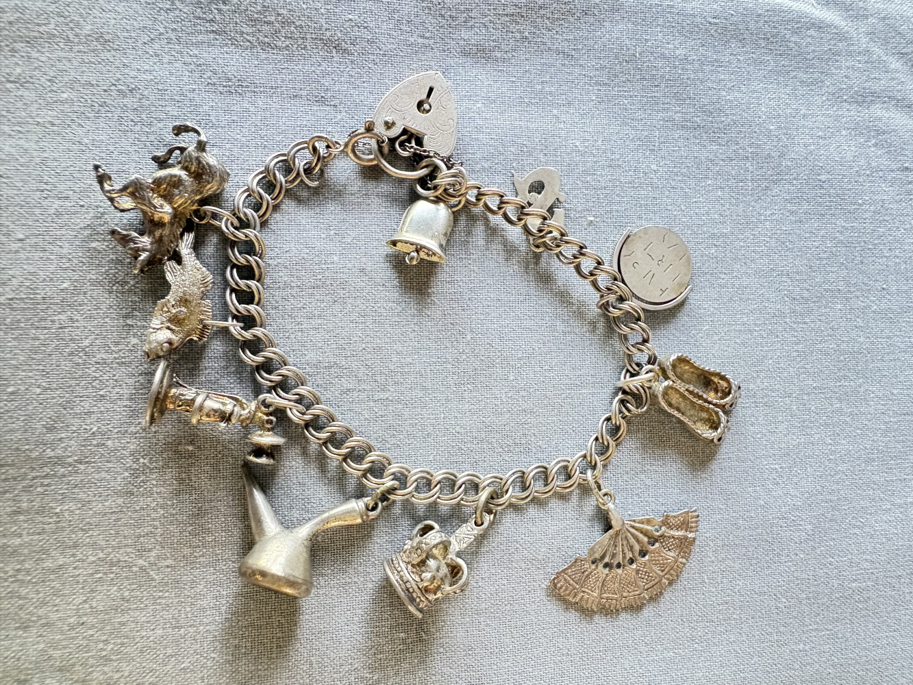 Metal Charm bracelet with some Silver hallmarked charms