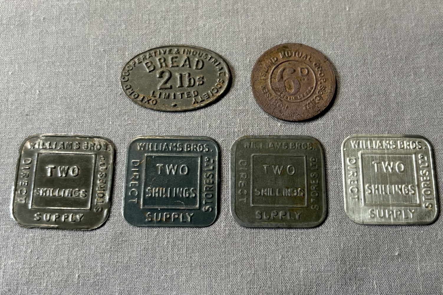 Vintage British trade and co-operative store tokens used as internal currency or loyalty rewards during the 20th century