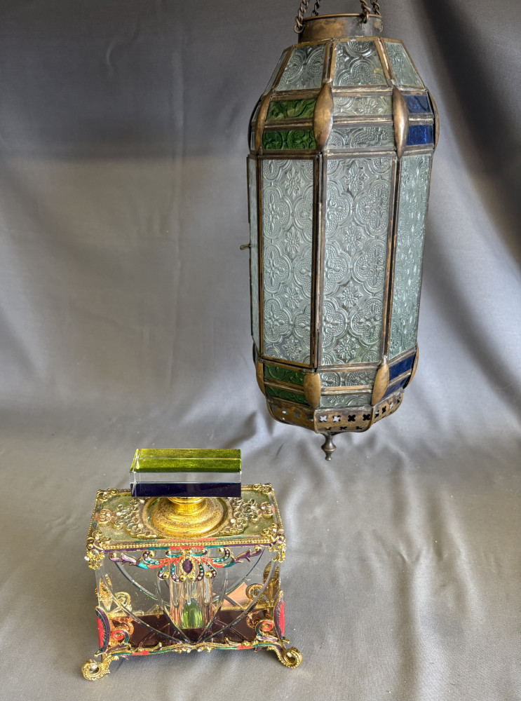 Ornate antique cut-glass perfume bottle featuring a gilded metal frame, and vintage hexagonal metal and patterned glass hanging lantern
