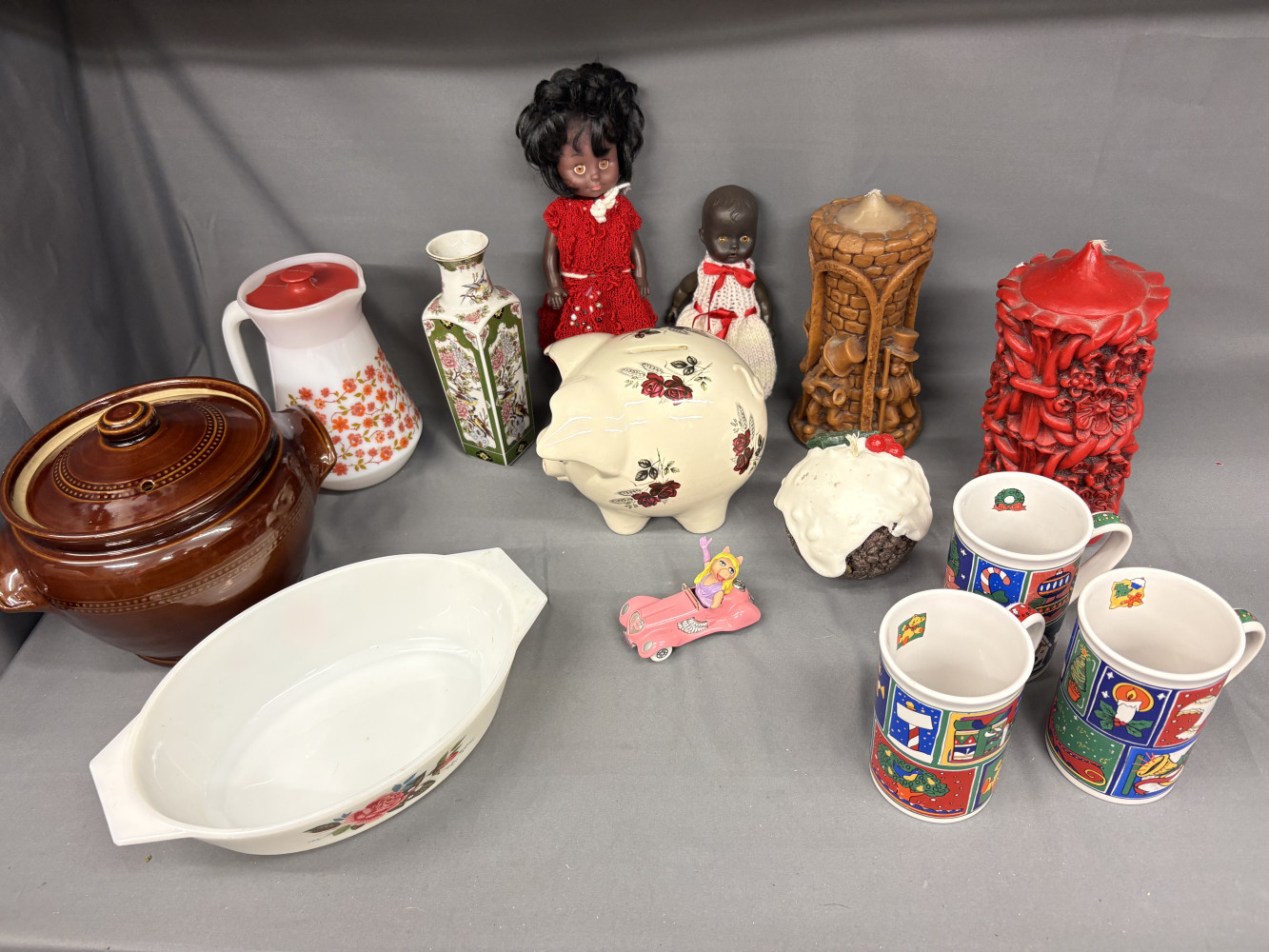 Mixed household items piggy bank, corgi car, large candles, mugs, dolls and other items