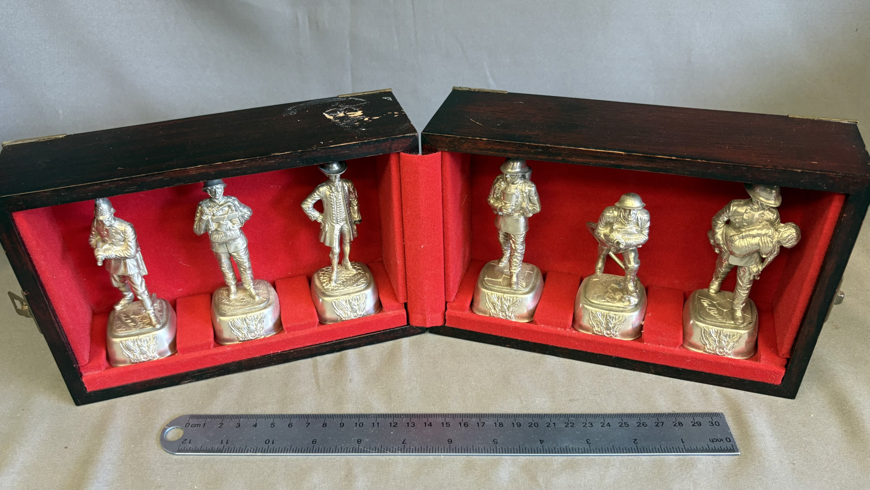 Set of vintage pewter firefighter figurines titled "Firemen Through The Ages," sculpted by Chas E. Stadden