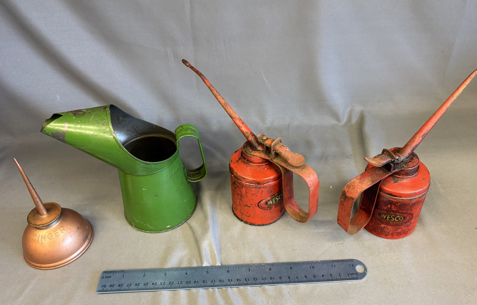 Vintage oil jug and two vintage Wesco pump-action oil can and singer oiler