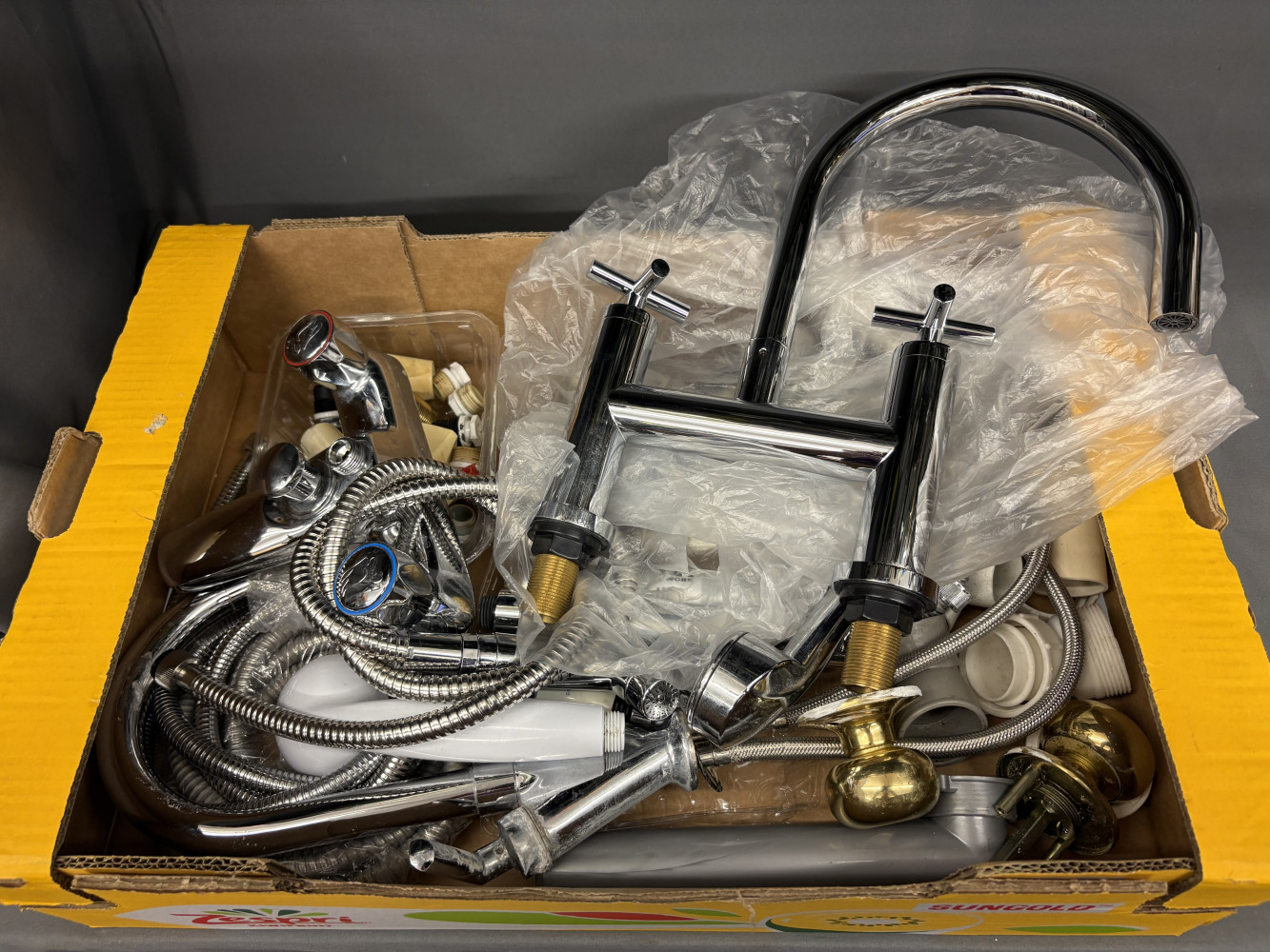 New bath tap and box of plumbing spares,